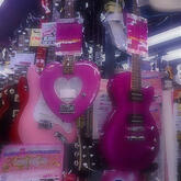 Pink guitars in a guitar shop with a soft blur